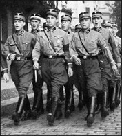 Young Nazi soldiers marching down a street in Germany.