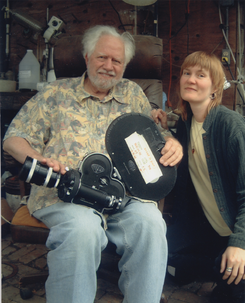 Sasha Shulgin sitting with  movie camera on his lap with Connie Littlefield beside him. 