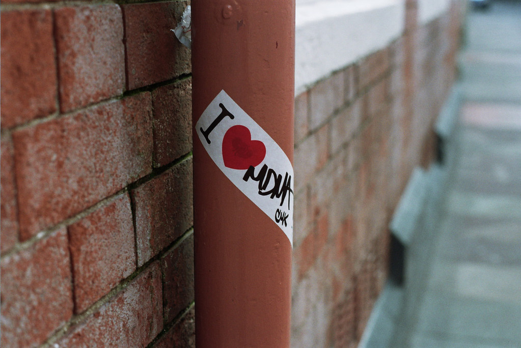 A sticker on a pole states "I heart MDMA"