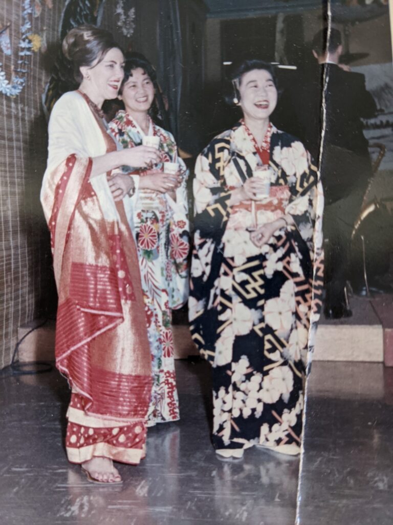 Three women (one white and two Japanese) stand smiling dressed in traditional Japanese garb