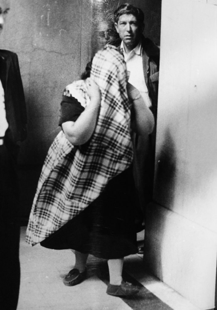 Lola La Chata in 1957 walking with a piece of cloth covering her face