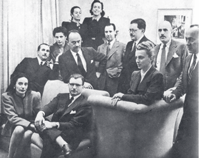 A group of Argentinian psychoanalysts pose on and around a sofa and chairs.
