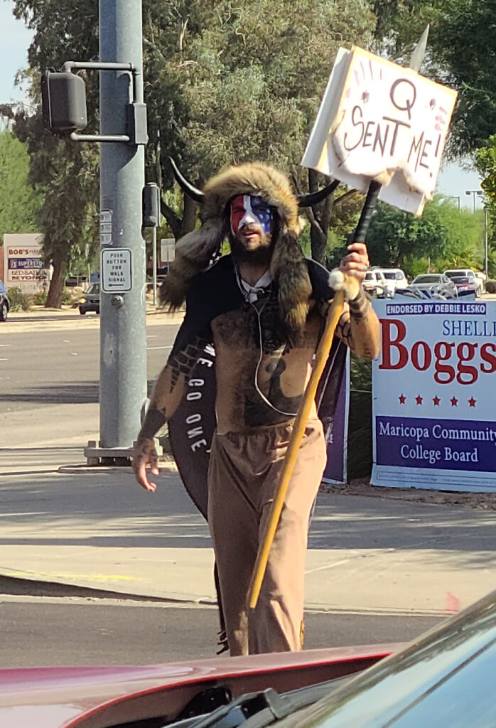 Jake Angeli (Qanon Shamon), seen holding a Qanon sign. Angeli is a famous example of conspirituality.