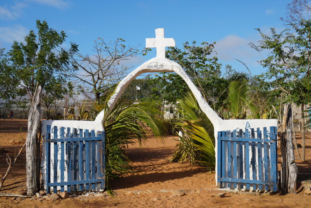 A white arch with a cross that leads to the chapel.