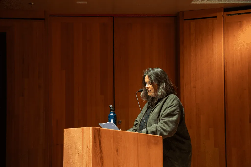 Bia Labate stands at podium on a stage delivering the keynote address at the Arctic Visions Psychedelic Conference